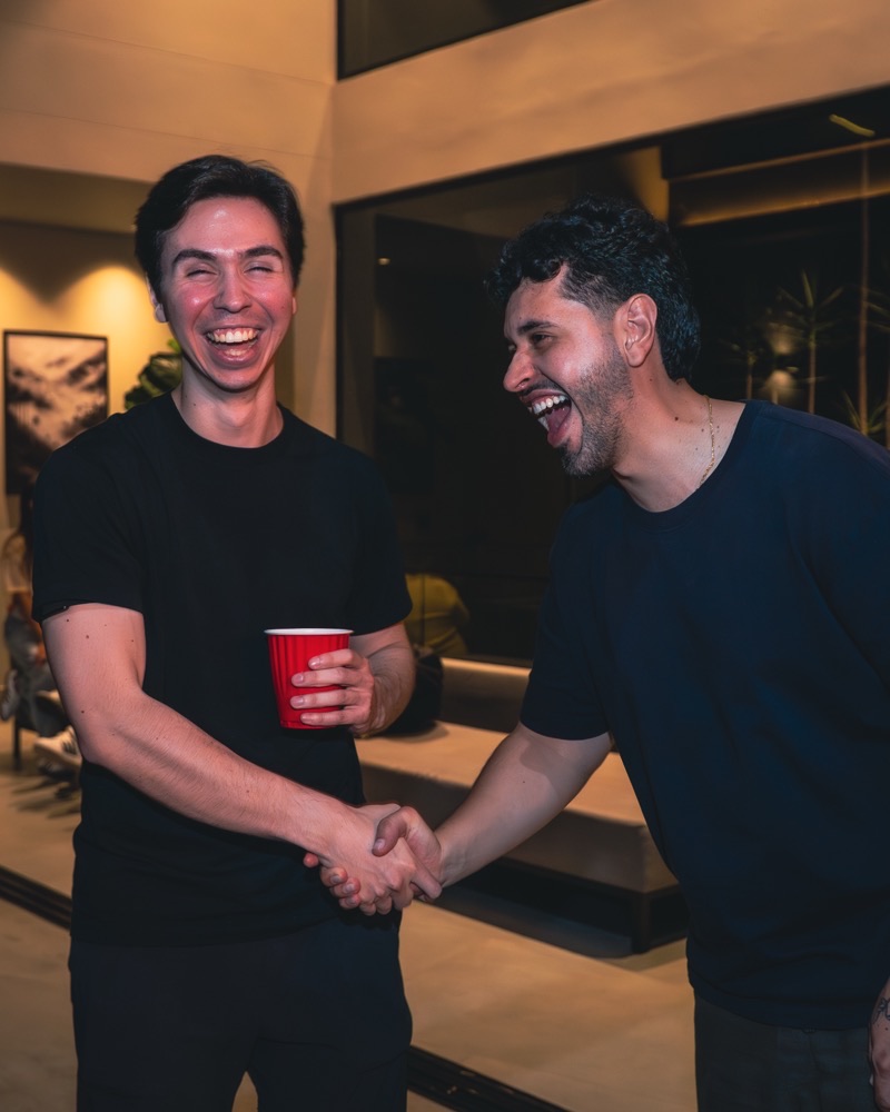 Alex Peñuñuri saludando a otro fundador en un evento